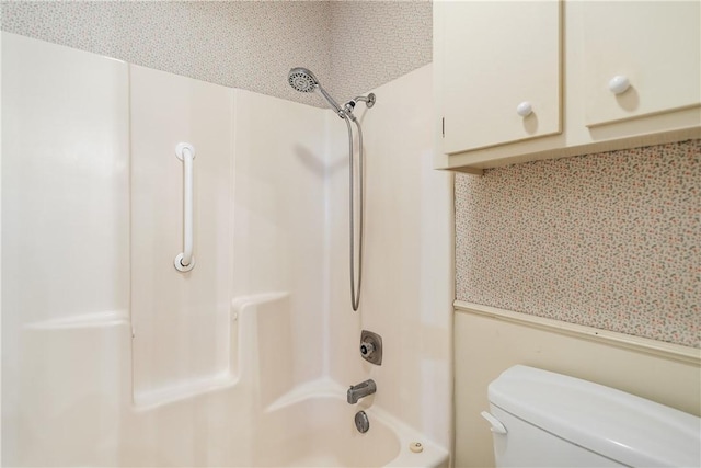 bathroom featuring shower / bathing tub combination and toilet