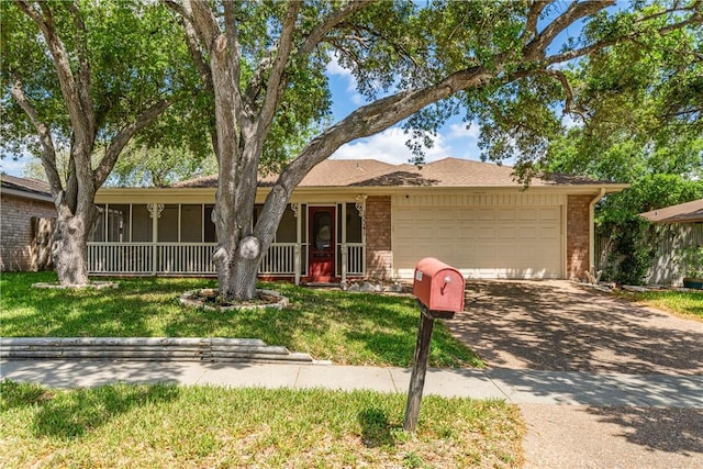 ranch-style house with brick siding, an attached garage, a front lawn, and driveway