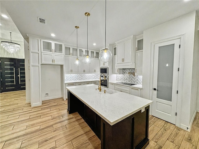 113 Gonzalez Dr, San Juan, TX 78589 - kitchen with stainless steel appliances, light wood-style floors, white cabinetry, decorative backsplash, and recessed lighting