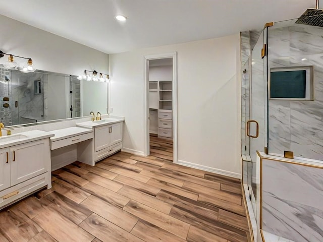 113 Gonzalez Dr, San Juan, TX 78589 - bathroom with a marble finish shower, wood finished floors, vanity, a walk in closet, and recessed lighting