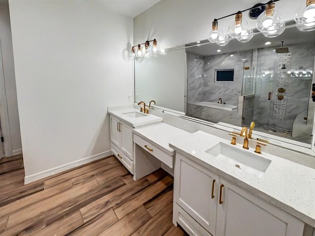 113 Gonzalez Dr, San Juan, TX 78589 - full bath featuring a stall shower, a bath, wood finished floors, double vanity, and baseboards