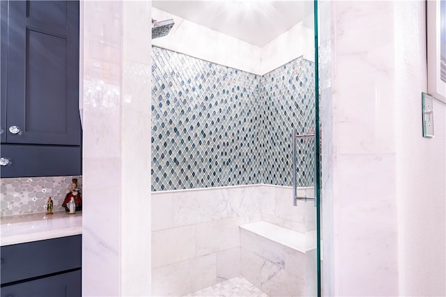 bathroom featuring vanity, tile walls, and a tile shower