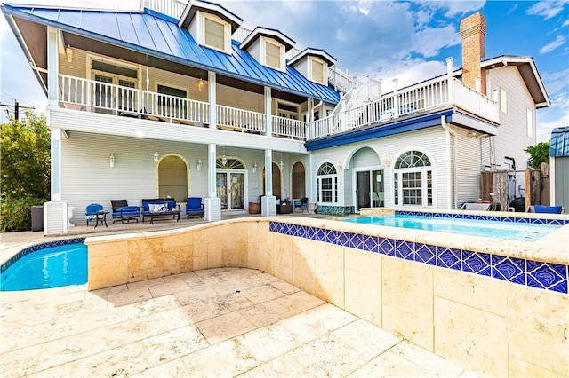 121 Glenmore St, Corpus Christi, TX 78412 - back of property featuring a balcony, a patio area, a standing seam roof, and an outdoor pool