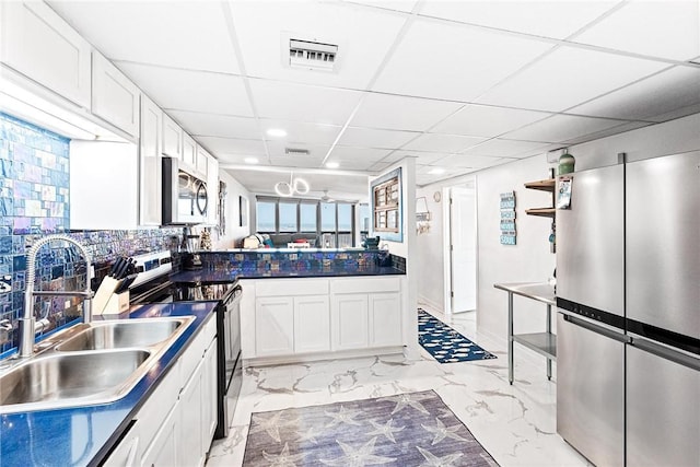 kitchen featuring visible vents, marble finish floor, stainless steel microwave, a sink, and range with electric stovetop