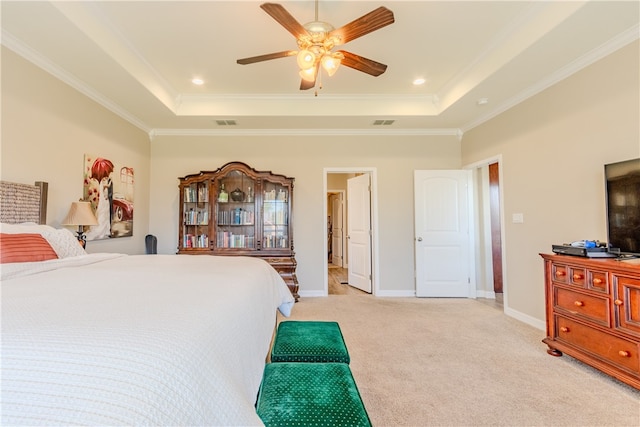 bedroom with ornamental molding, light colored carpet, ceiling fan, and a raised ceiling