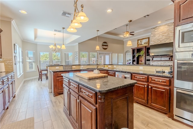 kitchen with a tray ceiling, hanging light fixtures, and a spacious island