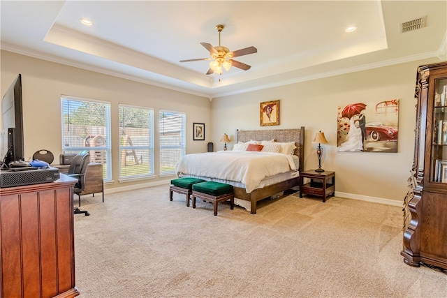 carpeted bedroom with ornamental molding, ceiling fan, and a raised ceiling