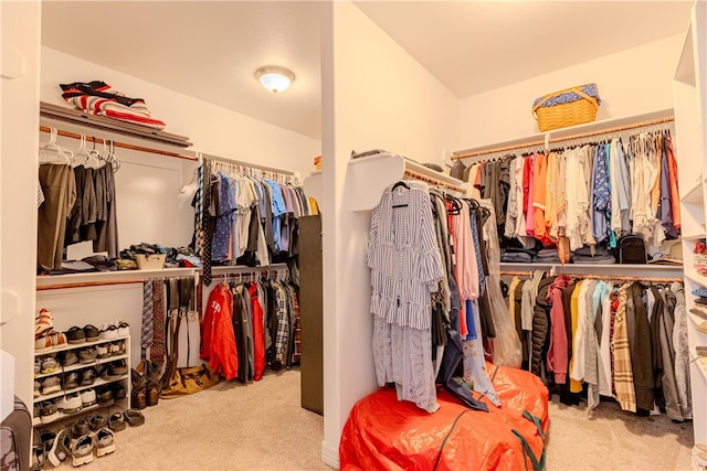 spacious closet featuring light colored carpet