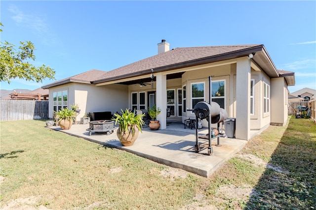 back of property with a patio, a lawn, and ceiling fan