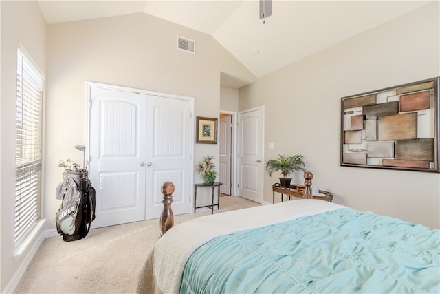 bedroom featuring ceiling fan, light carpet, a closet, and lofted ceiling