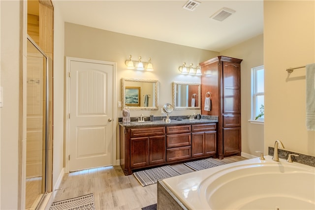 bathroom featuring vanity, hardwood / wood-style flooring, and plus walk in shower