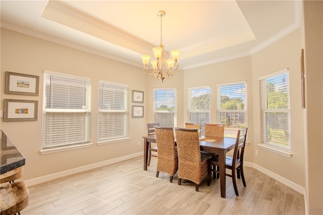 dining room featuring a tray ceiling, light hardwood / wood-style floors, and plenty of natural light