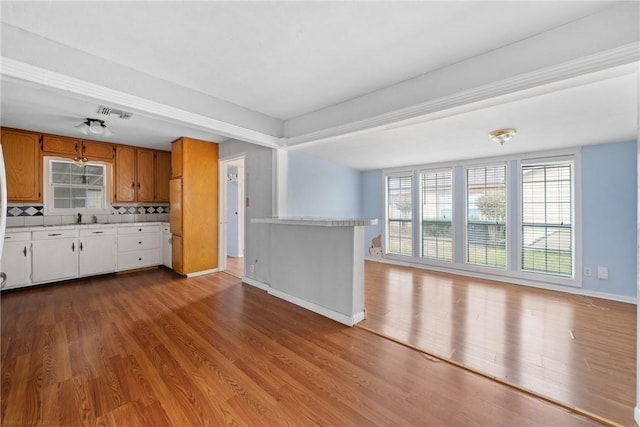 kitchen with white cabinetry, sink, ceiling fan, decorative backsplash, and light wood-type flooring