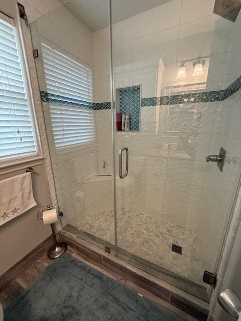 bathroom featuring a shower stall, baseboards, and wood finished floors