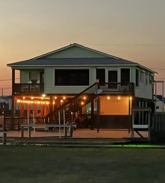 back of house at dusk featuring stairway