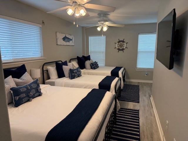 bedroom featuring ceiling fan, baseboards, and wood finished floors