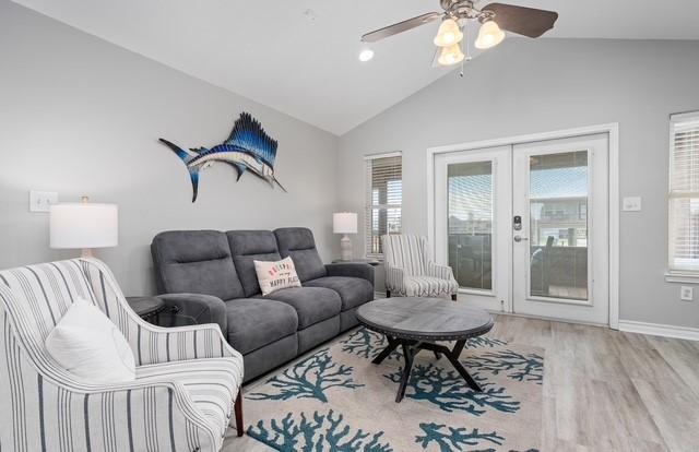 living room featuring ceiling fan, wood finished floors, baseboards, vaulted ceiling, and french doors