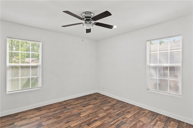unfurnished room with baseboards, ceiling fan, and dark wood-type flooring
