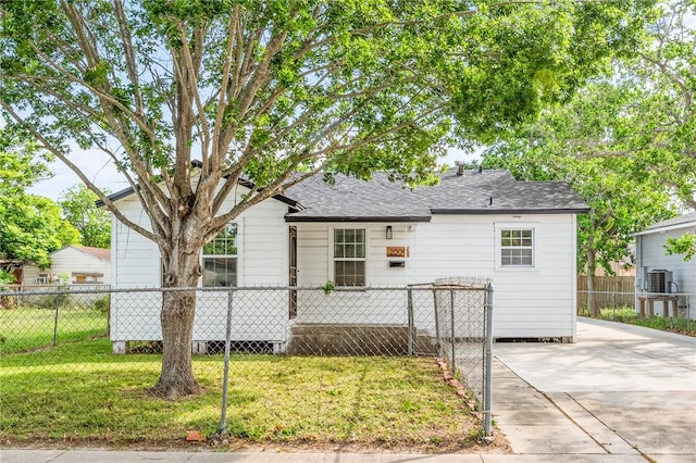 bungalow with fence private yard, roof with shingles, and a front lawn