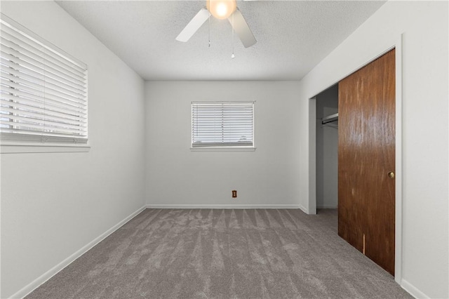 unfurnished bedroom with carpet, a closet, multiple windows, and ceiling fan