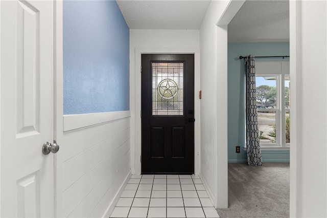 carpeted entryway featuring a healthy amount of sunlight and a textured ceiling