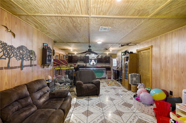 living room with ceiling fan, wooden walls, and wood ceiling