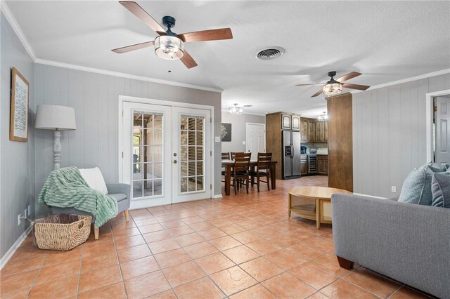 2575 Arkansas St, Ingleside, TX 78362 - living room featuring french doors, ceiling fan, crown molding, light tile patterned flooring, and wooden walls