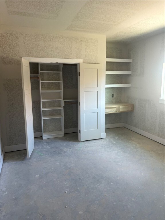 unfurnished bedroom with concrete floors and a textured ceiling