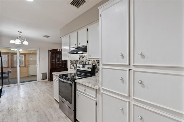 kitchen with under cabinet range hood, visible vents, stainless steel range with electric stovetop, and tasteful backsplash