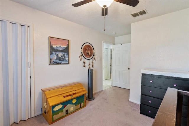 bedroom featuring visible vents, light carpet, a textured ceiling, and baseboards