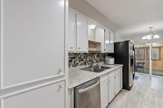 kitchen featuring tasteful backsplash, white cabinets, appliances with stainless steel finishes, and a sink