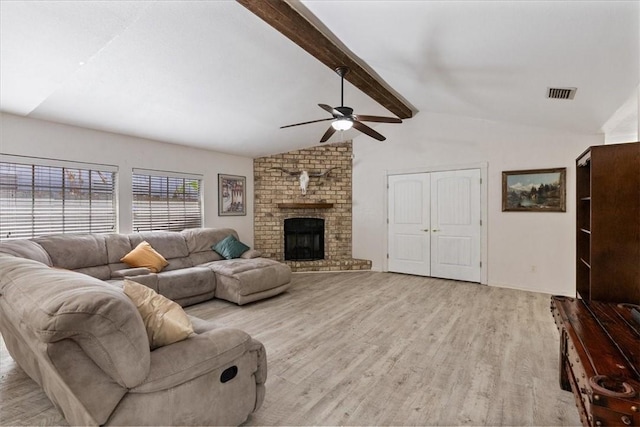 living room with visible vents, light wood finished floors, vaulted ceiling with beams, a fireplace, and ceiling fan