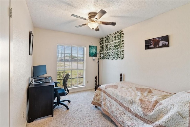 bedroom with a textured ceiling, a ceiling fan, and carpet floors