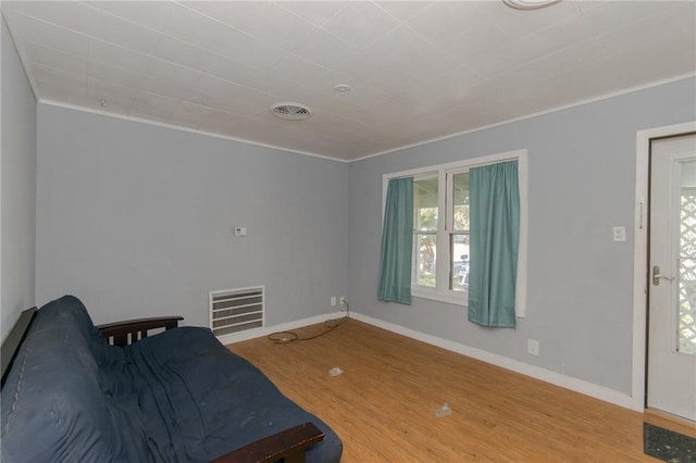 living area featuring ornamental molding and wood-type flooring