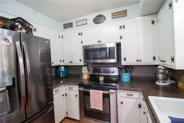 1512 Palo Blanco, Beeville, TX 78102 - kitchen featuring dark countertops, white cabinetry, and stainless steel appliances