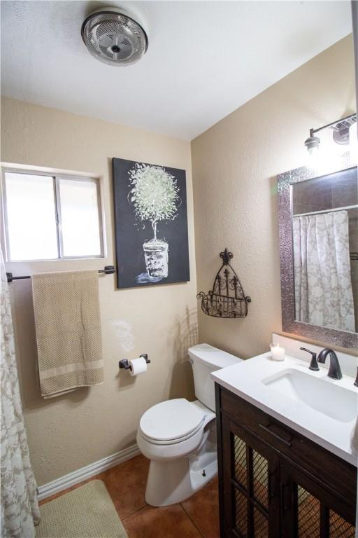 1512 Palo Blanco, Beeville, TX 78102 - full bathroom featuring vanity, toilet, baseboards, tile patterned flooring, and a shower with shower curtain