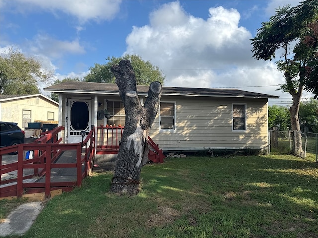 back of property featuring a wooden deck and a yard