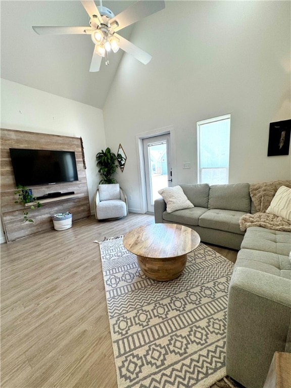 living room with high vaulted ceiling, ceiling fan, and light hardwood / wood-style floors