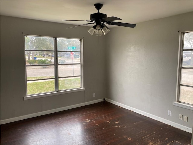 unfurnished room featuring baseboards, dark wood-type flooring, and a ceiling fan