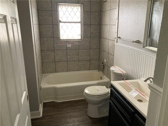 bathroom with vanity,  shower combination, toilet, and wood finished floors