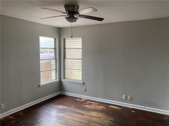 spare room with a ceiling fan, wood finished floors, baseboards, and a textured wall