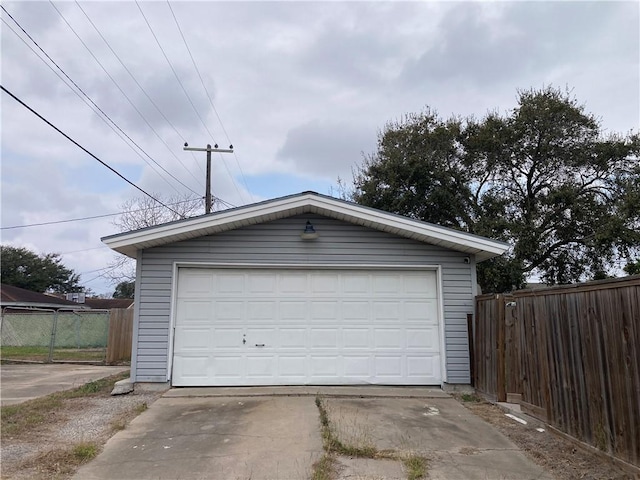 detached garage featuring fence