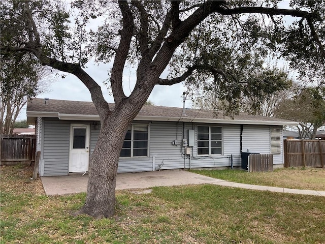 rear view of property with a yard, a patio, and fence