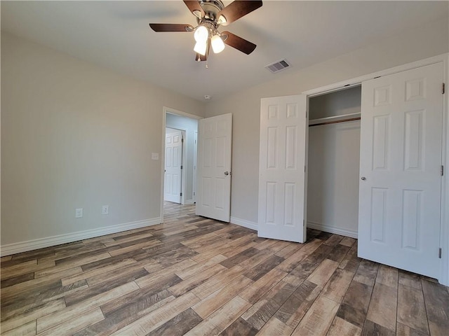 unfurnished bedroom featuring hardwood / wood-style flooring, ceiling fan, and a closet