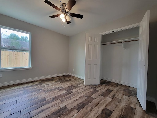 unfurnished bedroom featuring ceiling fan, a closet, and hardwood / wood-style floors