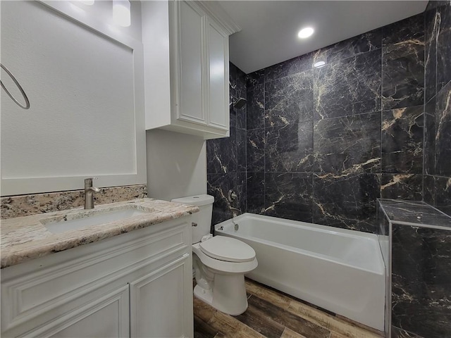 full bathroom with hardwood / wood-style floors, vanity, shower / bathtub combination, and toilet