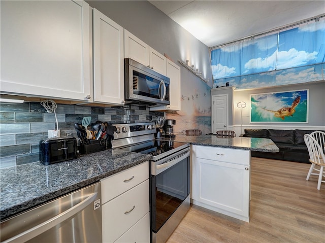 kitchen featuring light hardwood / wood-style flooring, backsplash, white cabinets, and stainless steel appliances