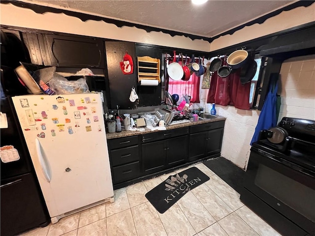 3751 Wilson Dr, Corpus Christi, TX 78408 - kitchen with electric range, dark cabinetry, and freestanding refrigerator