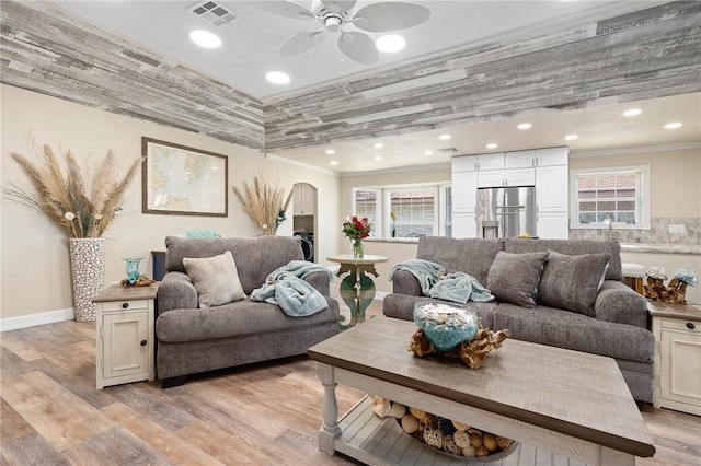 1214 Enterprise Blvd, Rockport, TX 78382 - living room with visible vents, ornamental molding, a ceiling fan, arched walkways, and light wood-type flooring