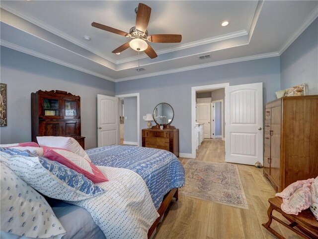 bedroom featuring crown molding, ceiling fan, light hardwood / wood-style floors, and a tray ceiling